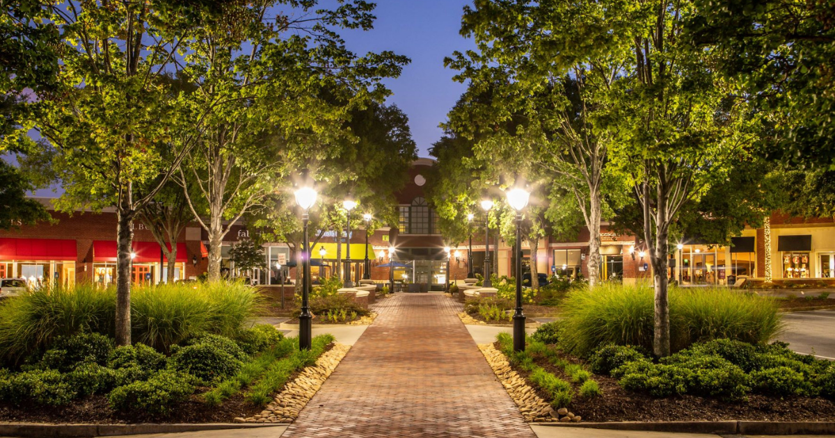 Sprinkler system running along a Peachtree City golf-cart path community lawn